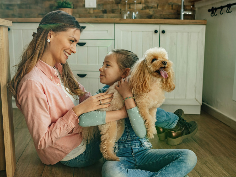 Mother, daughter, and poodle smiling