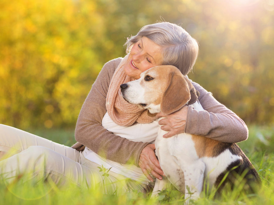 Elderly woman cuddling her beagle.