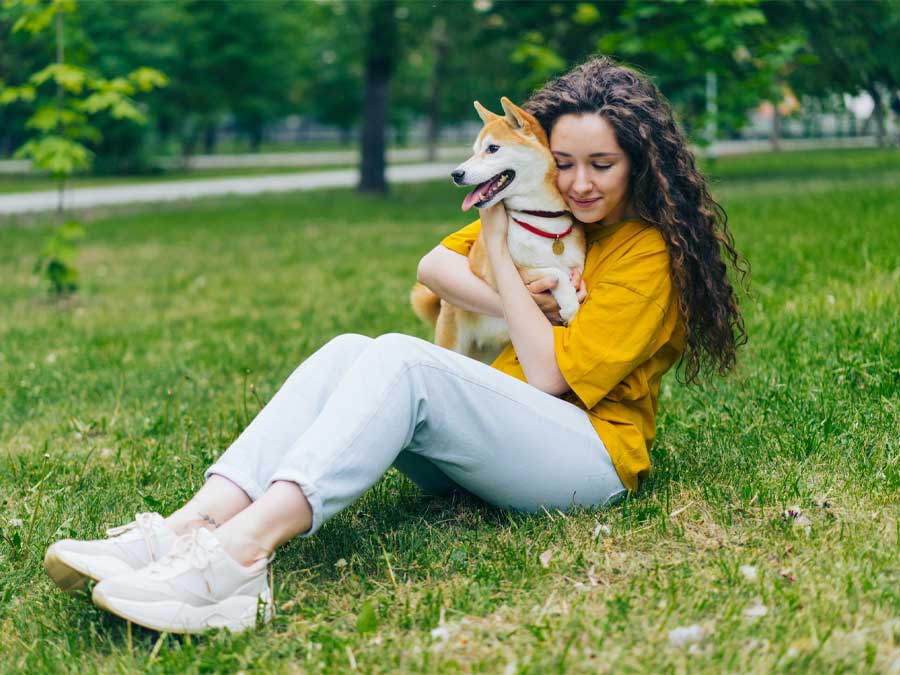 Woman hugging Shiba Inu dog.