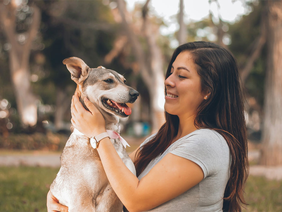 Woman smiles at dog in park