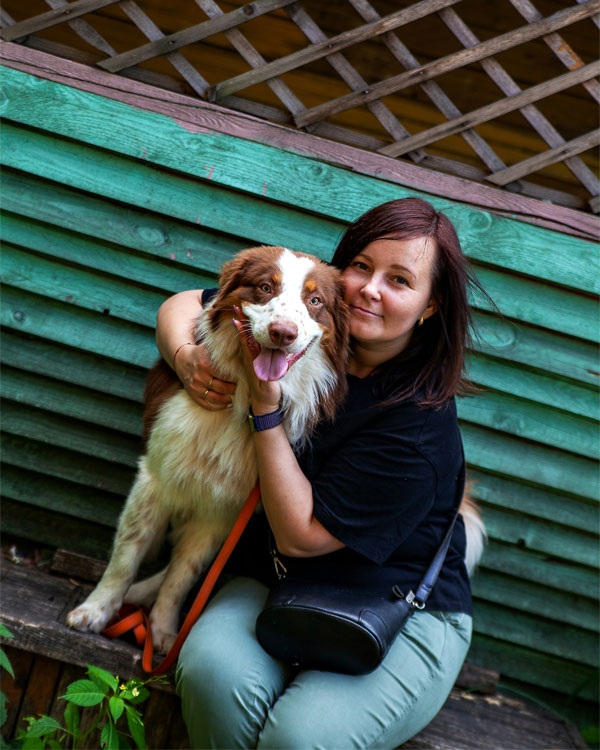 Woman hugs brown and white dog.