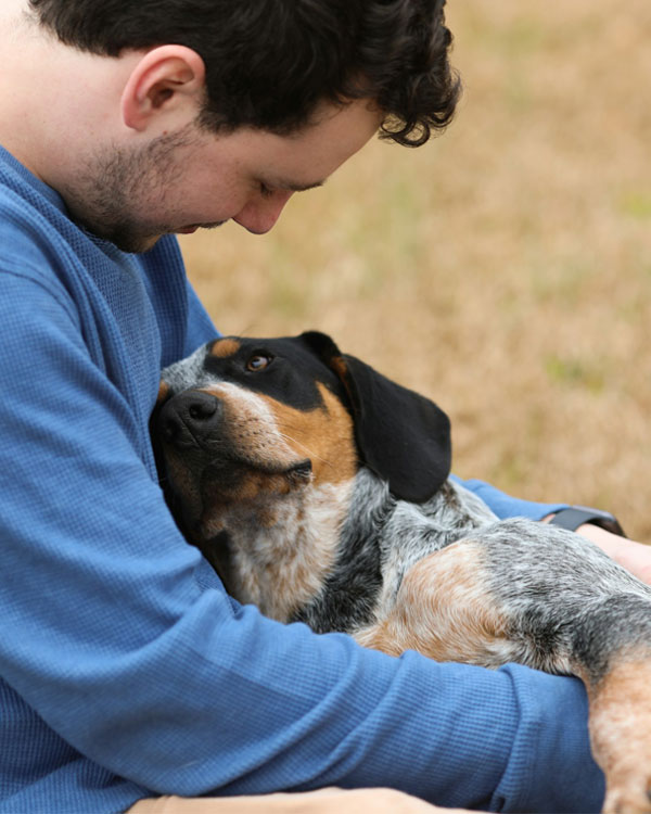 Owner lovingly embraces his dog.