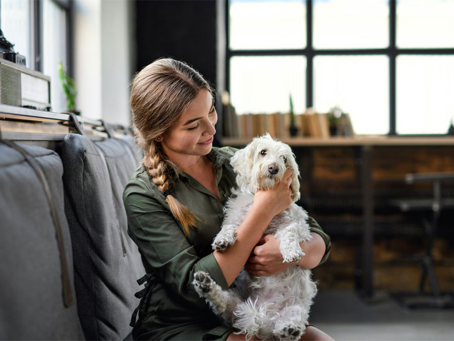 Girl holding a dog in her arms.
